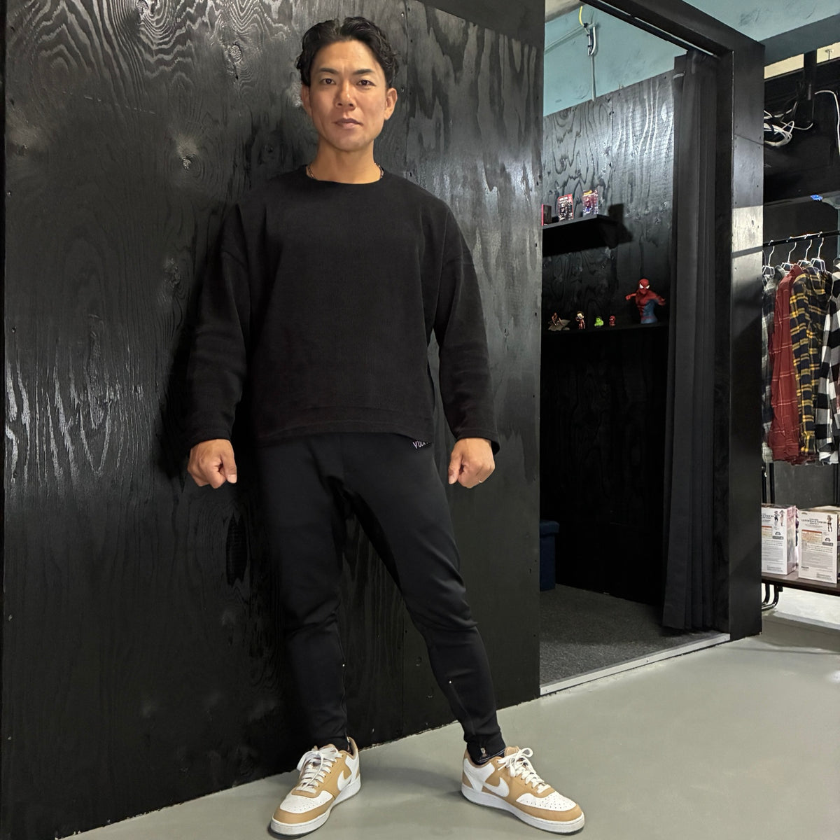 同じ人物が普段の細身パンツと黒いトップスを着用した姿